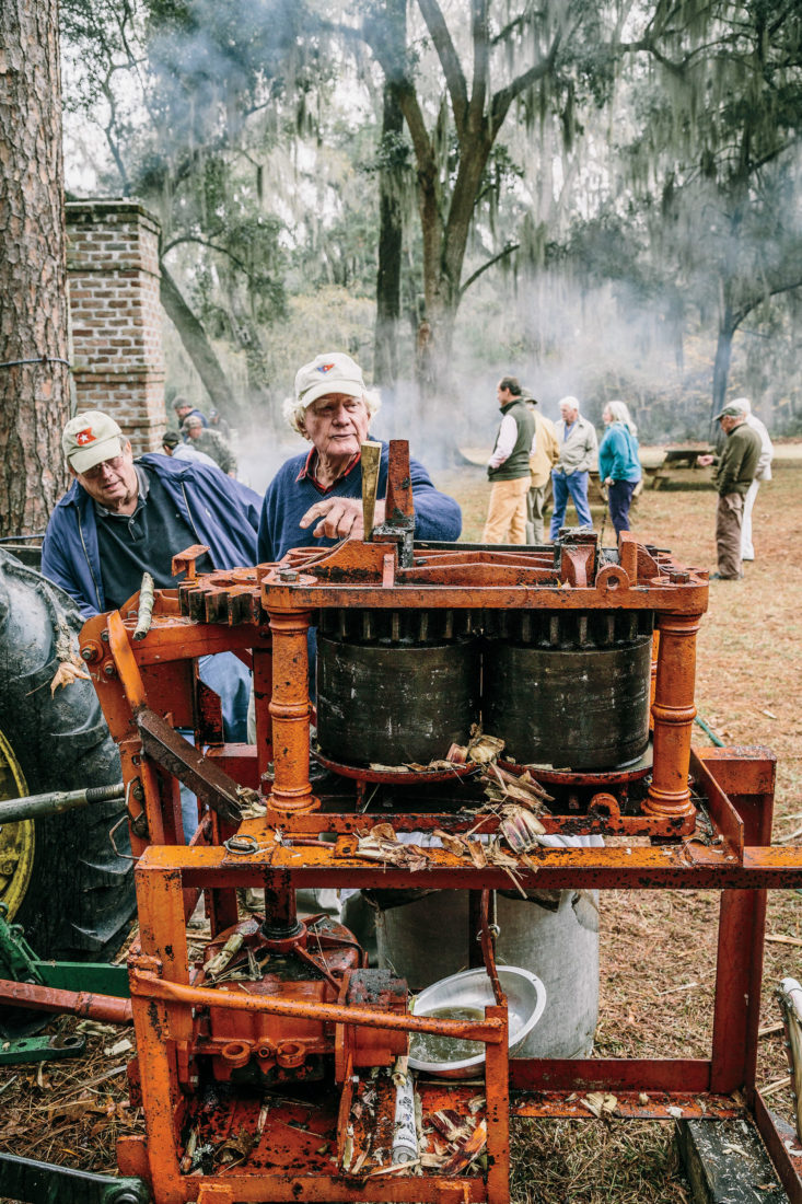 Maybank works the press, crushing and squeezing juice from fresh cane.