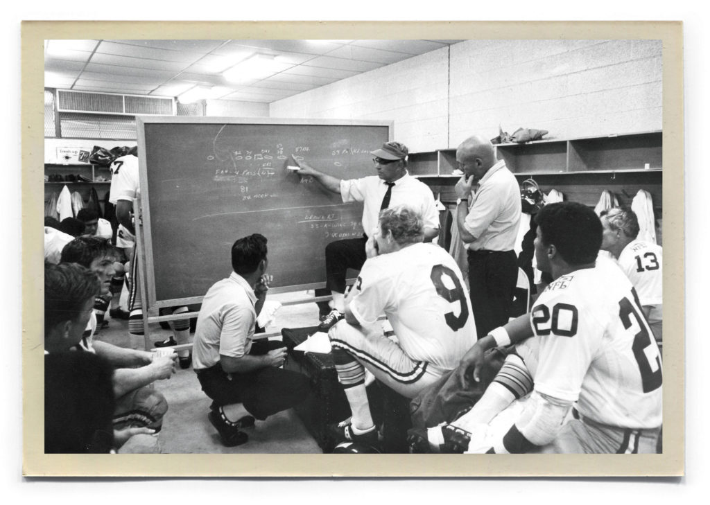 Players listen to Lombardi at halftime during the first game of the season, in New Orleans.