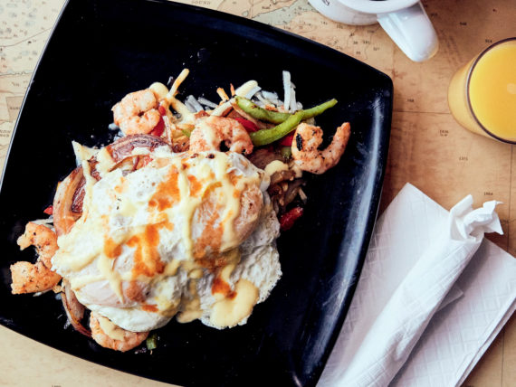hash browns, with shrimp and eggs on a plate
