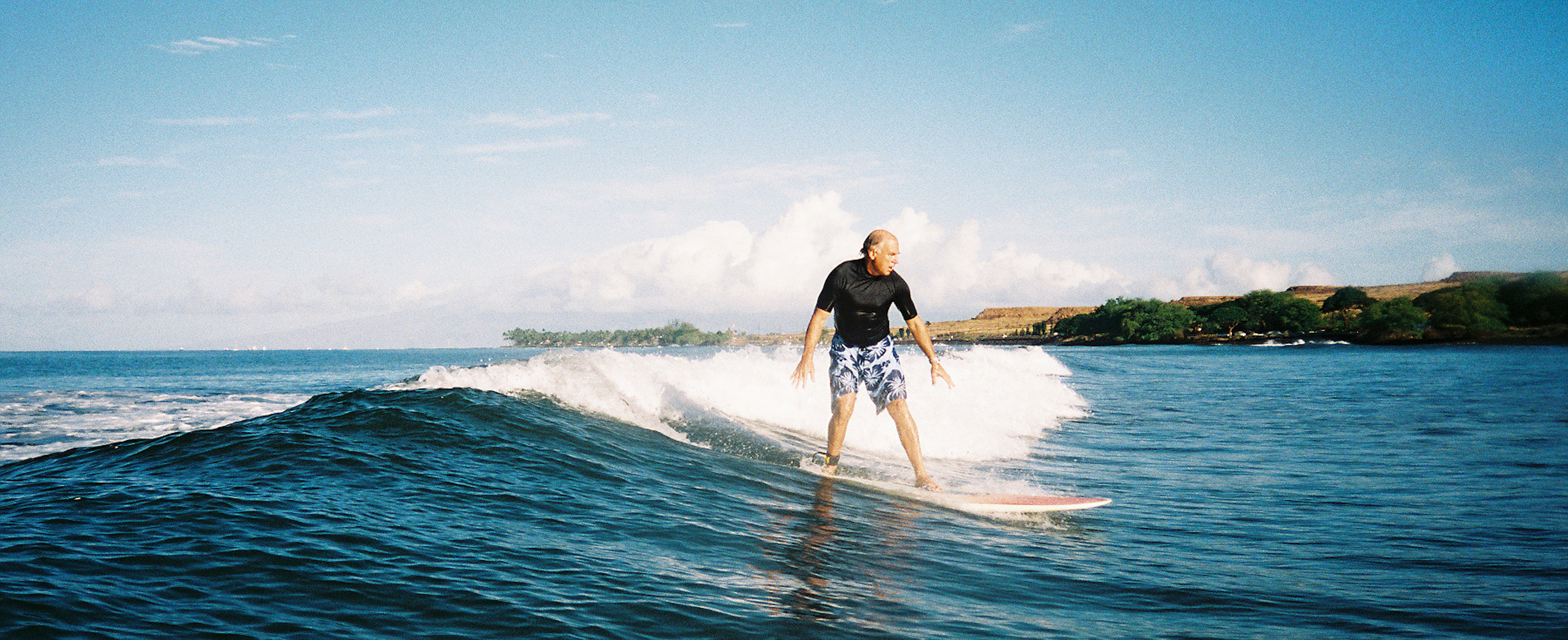 A man catches a wave on a surfboard