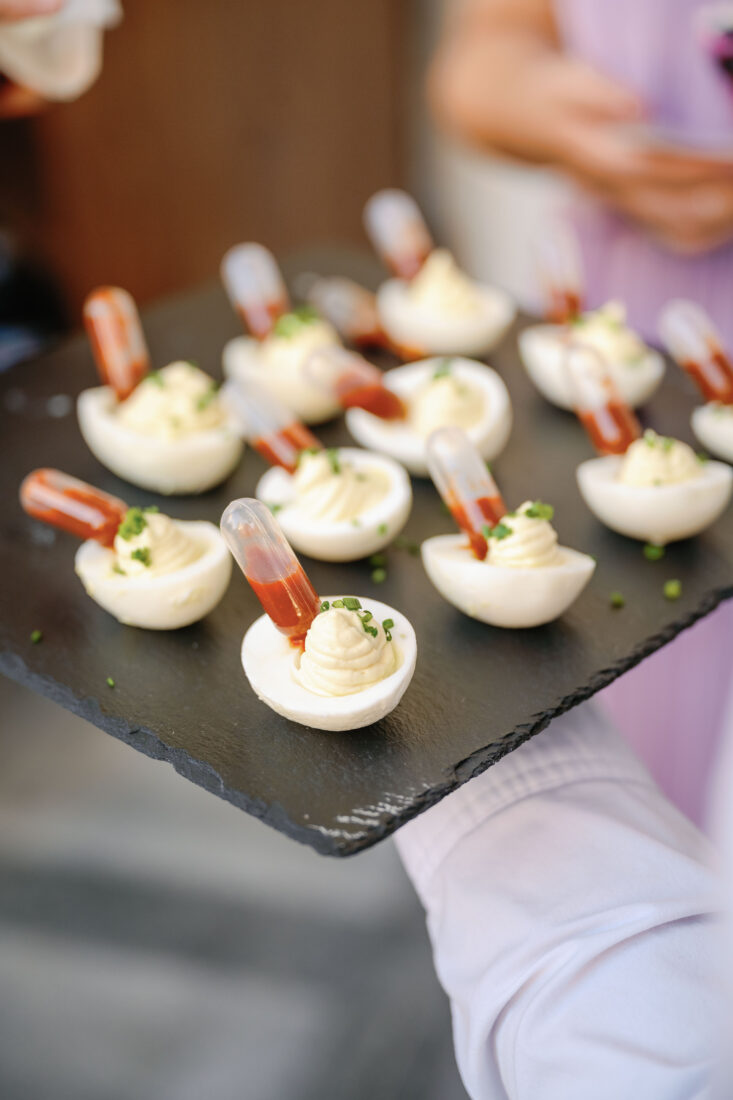 Deviled eggs with chives, black garlic, and hot su.