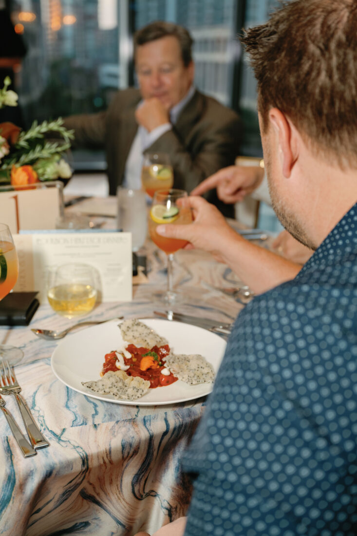 Guests seated for the first course of tuna tartar in gochujang vinaigrette with chili butter, Hon-shimeji mushrooms, and sesame crisps paired with a Blade and Bow Spritz, composed of Blade and Bow Kentucky Straight Bourbon Whiskey, strawberry cucumber syrup, and Natalie’s lemon juice.