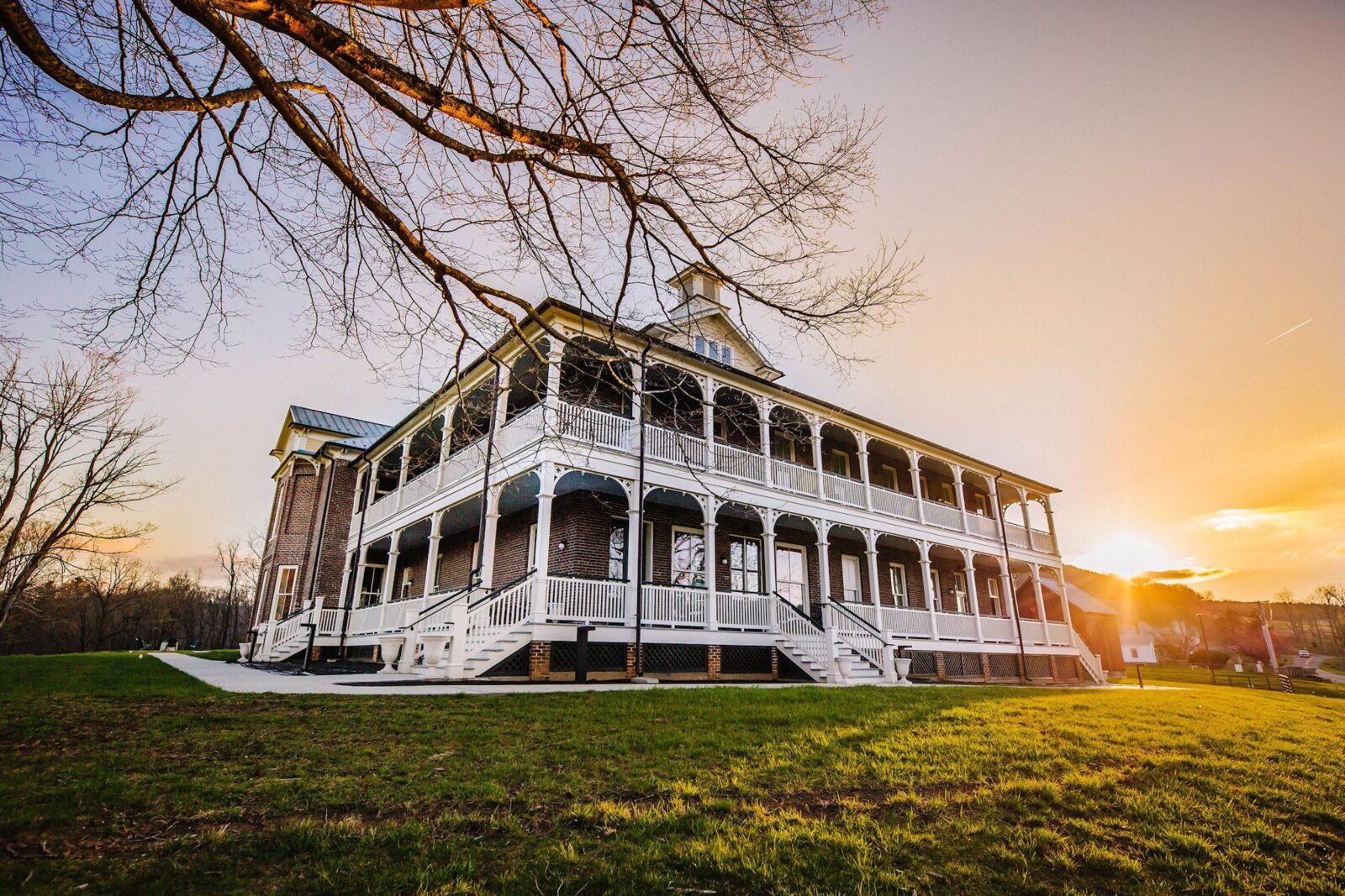 A large stately building with double-porches sits on a hill