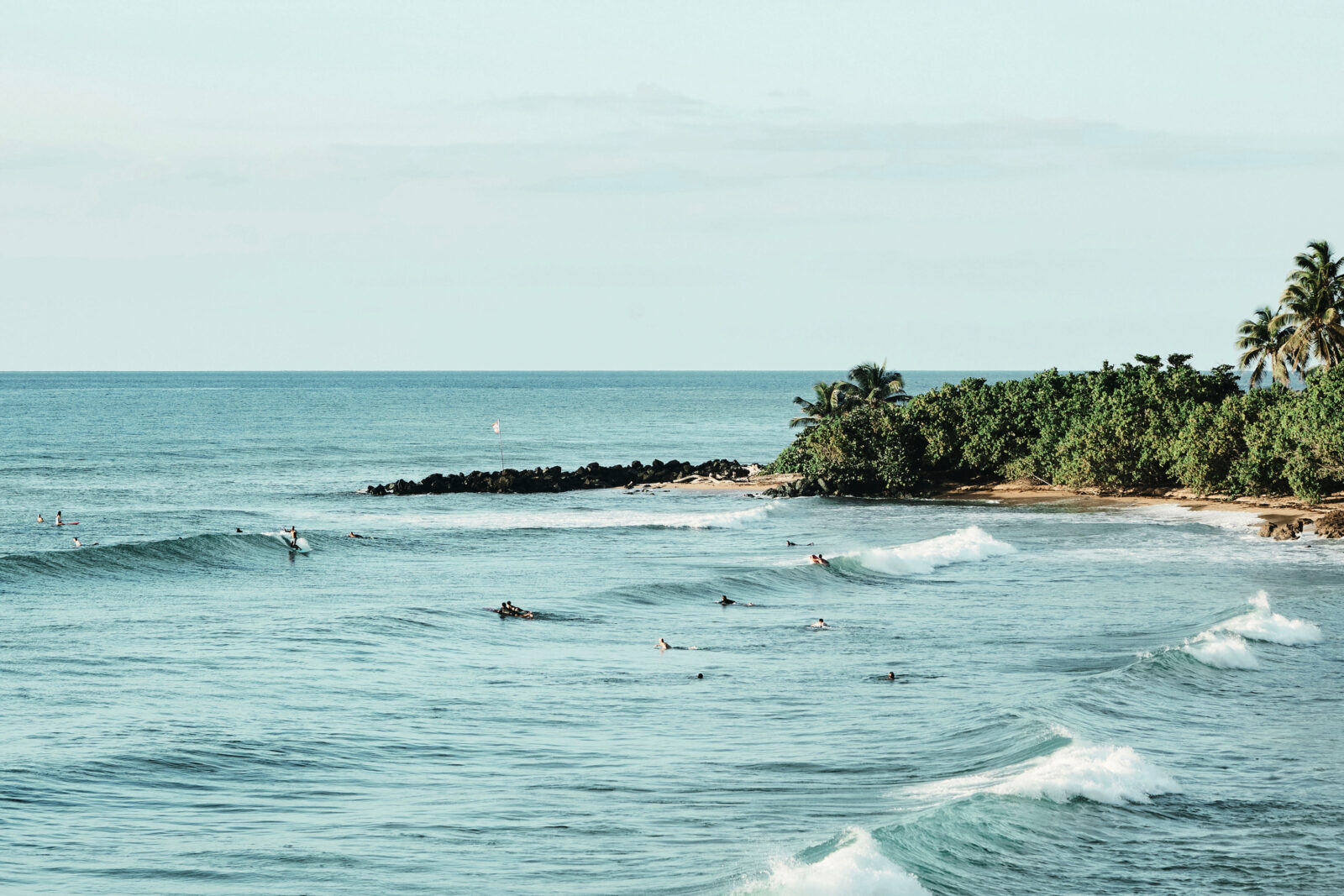 Surfers swim in blue ocean water