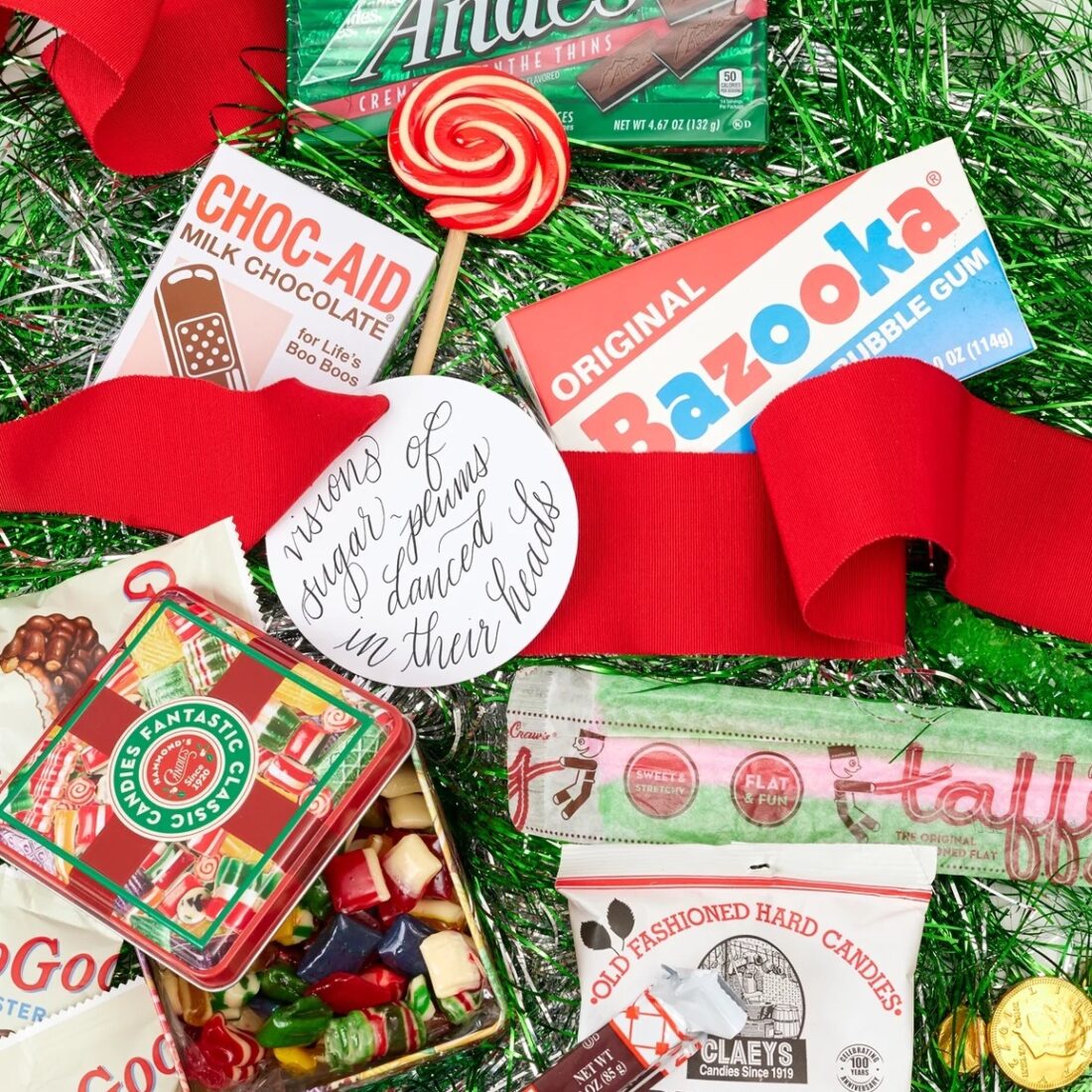 A collection of wrapped candy on a green sparkly background with red ribbon 