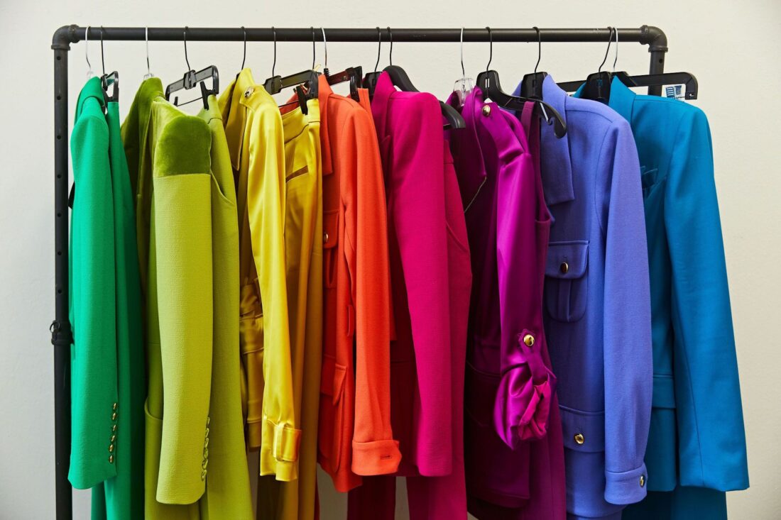 A rainbow of suits on a clothing rack