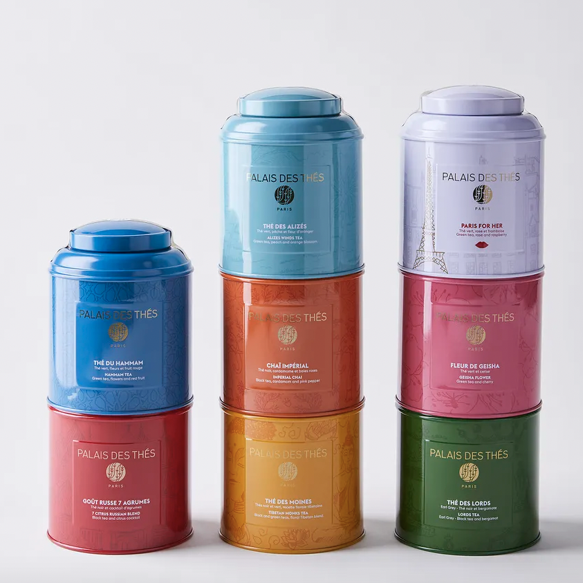 Three stacks of colorful tea tins