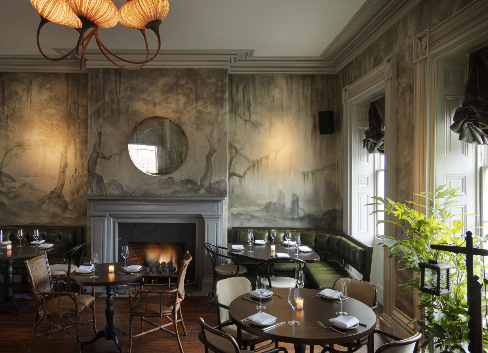 A dining room with painted walls and a couple of set tables