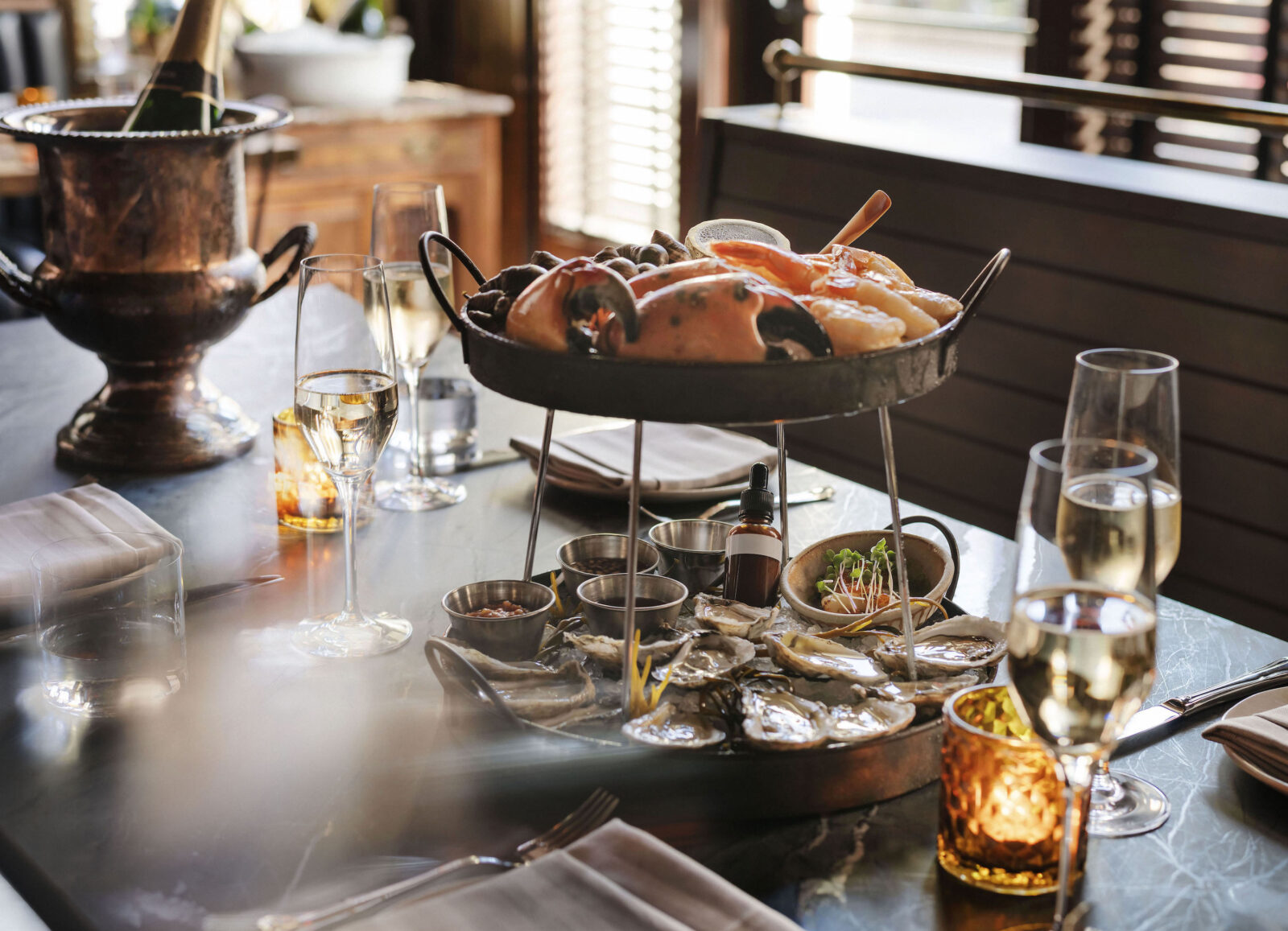 A table with wine glasses and a seafood tower