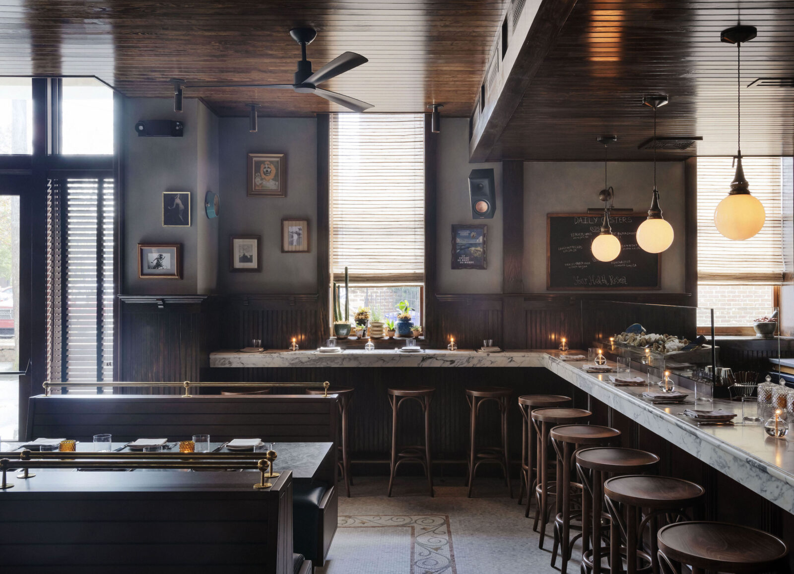 A dark dining room with a marble bar and bar stools