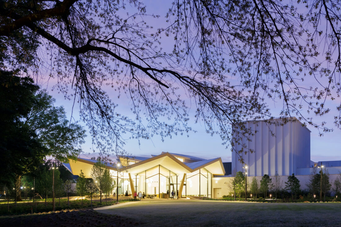 The outside of a museum; it is lit up and the sky is dark