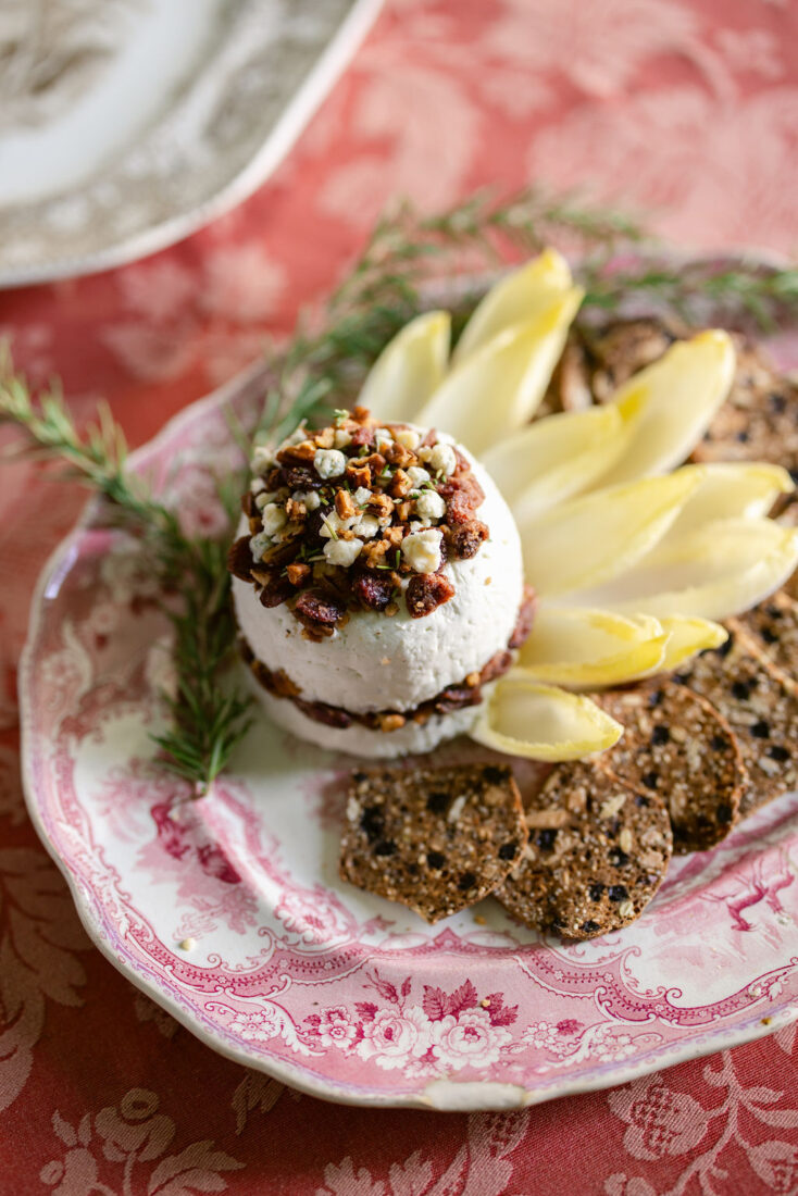 Blue cheese terrine with spiced pecans and cranberries on a plate