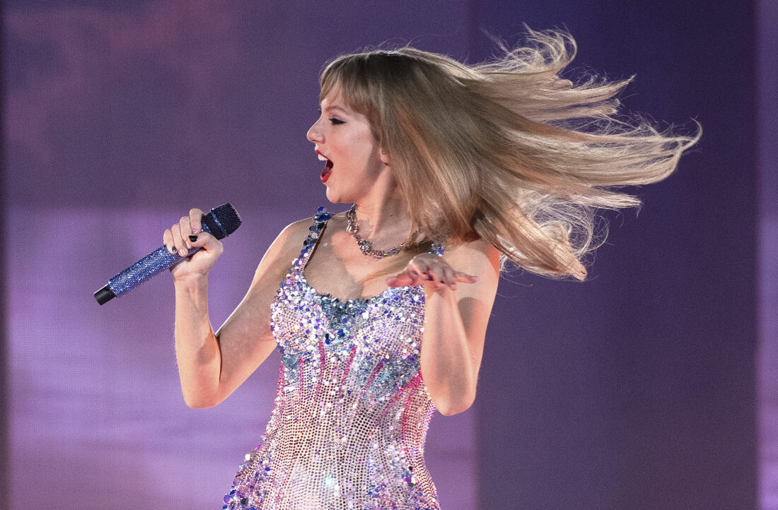 Taylor Swift in a bedazzled suit on a purple stage