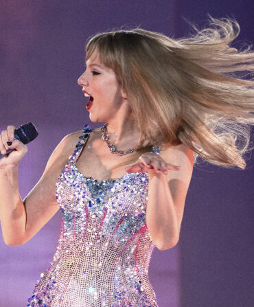 Taylor Swift in a bedazzled suit on a purple stage