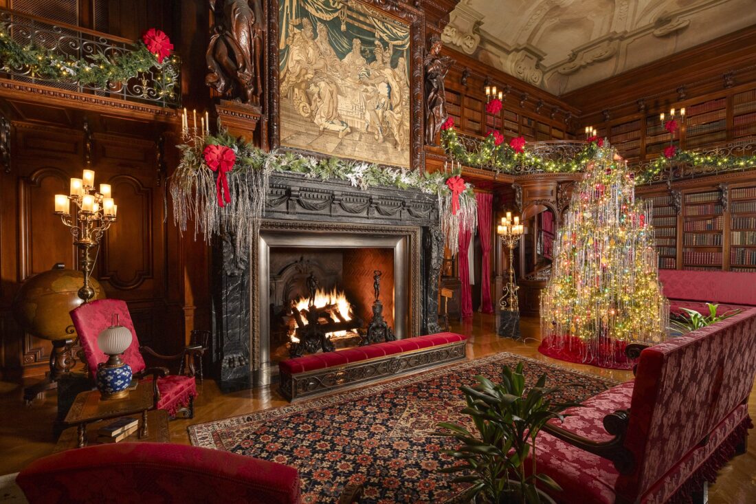 A grand living room with Christmas decor and a lit-up tree