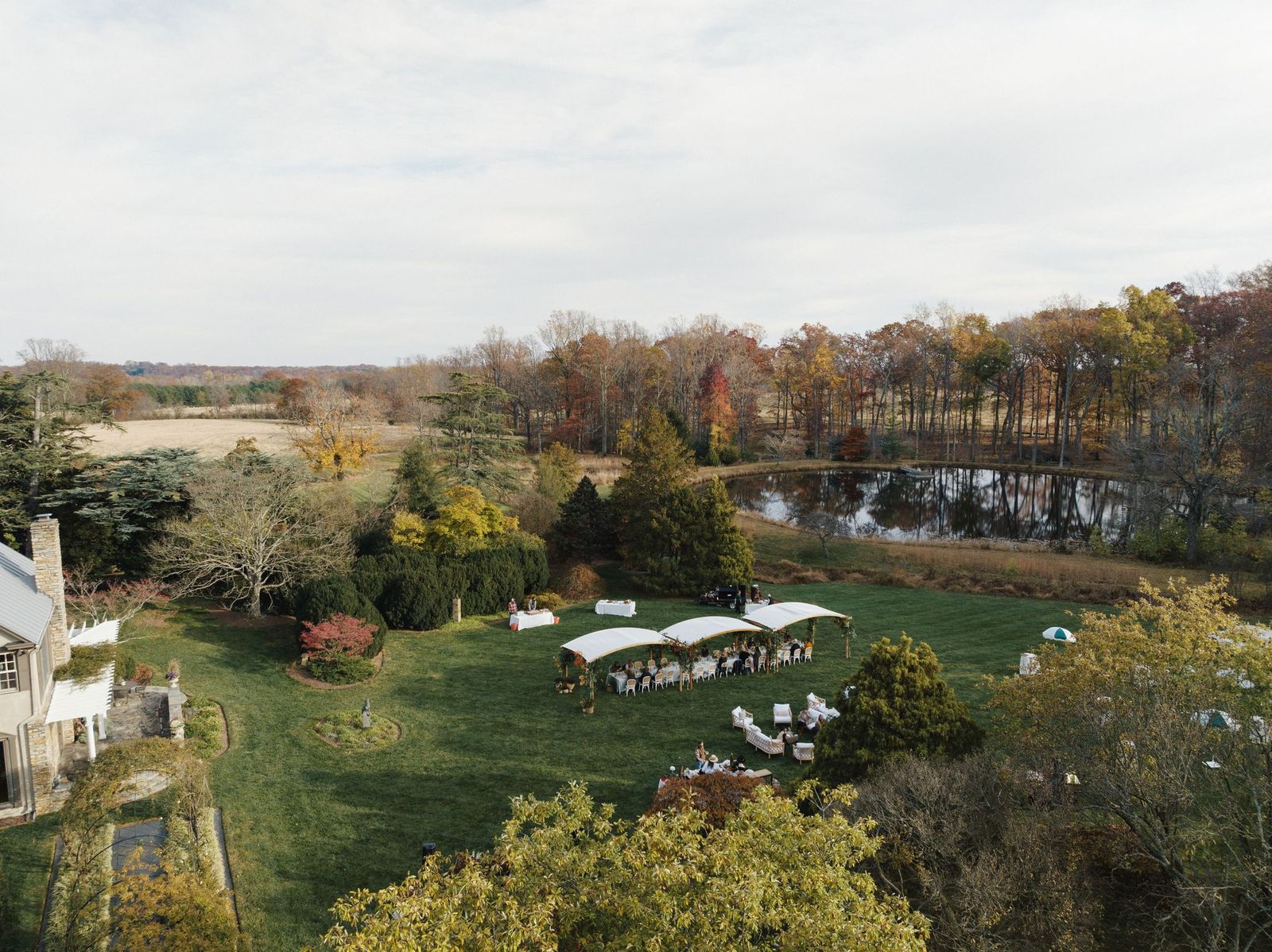 An aerial shot above the estate shows a tent set up for events in a garden