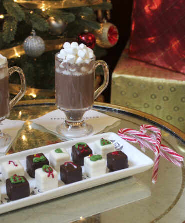 A silver tray with chocolates and hot chocolate