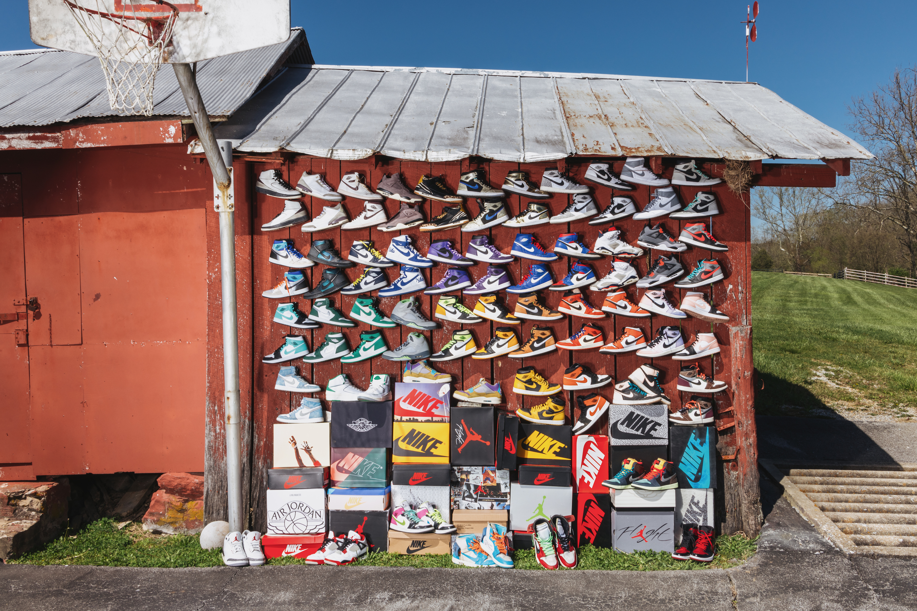 A collection of Air Jordans stacked against a red barn