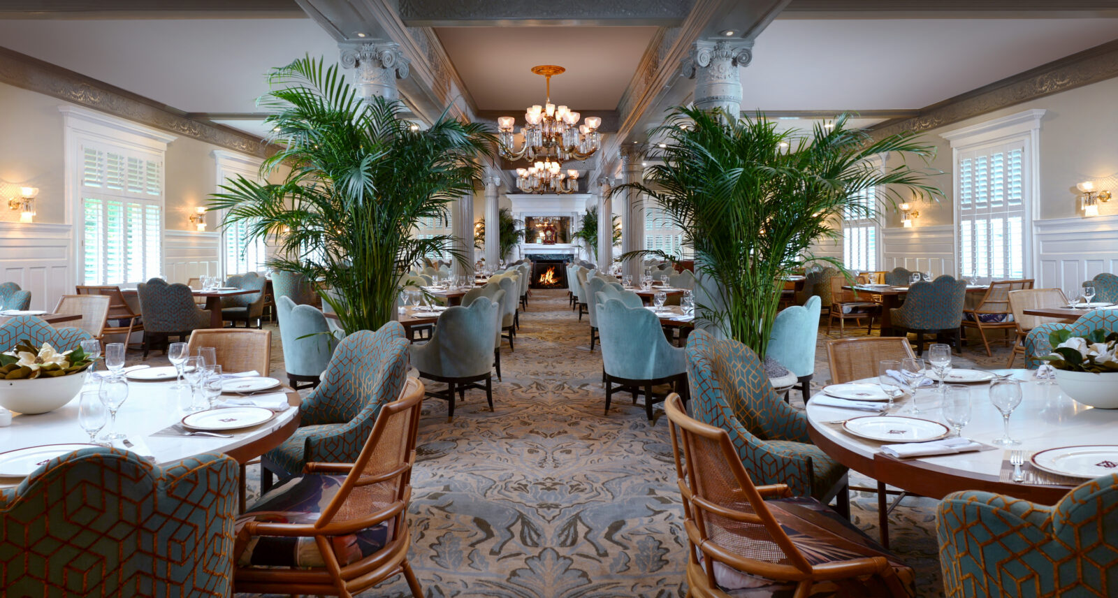 A grand dining room with horse patterns on the carpet and tables