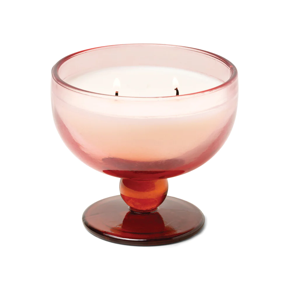 A candle in a pink glass cup