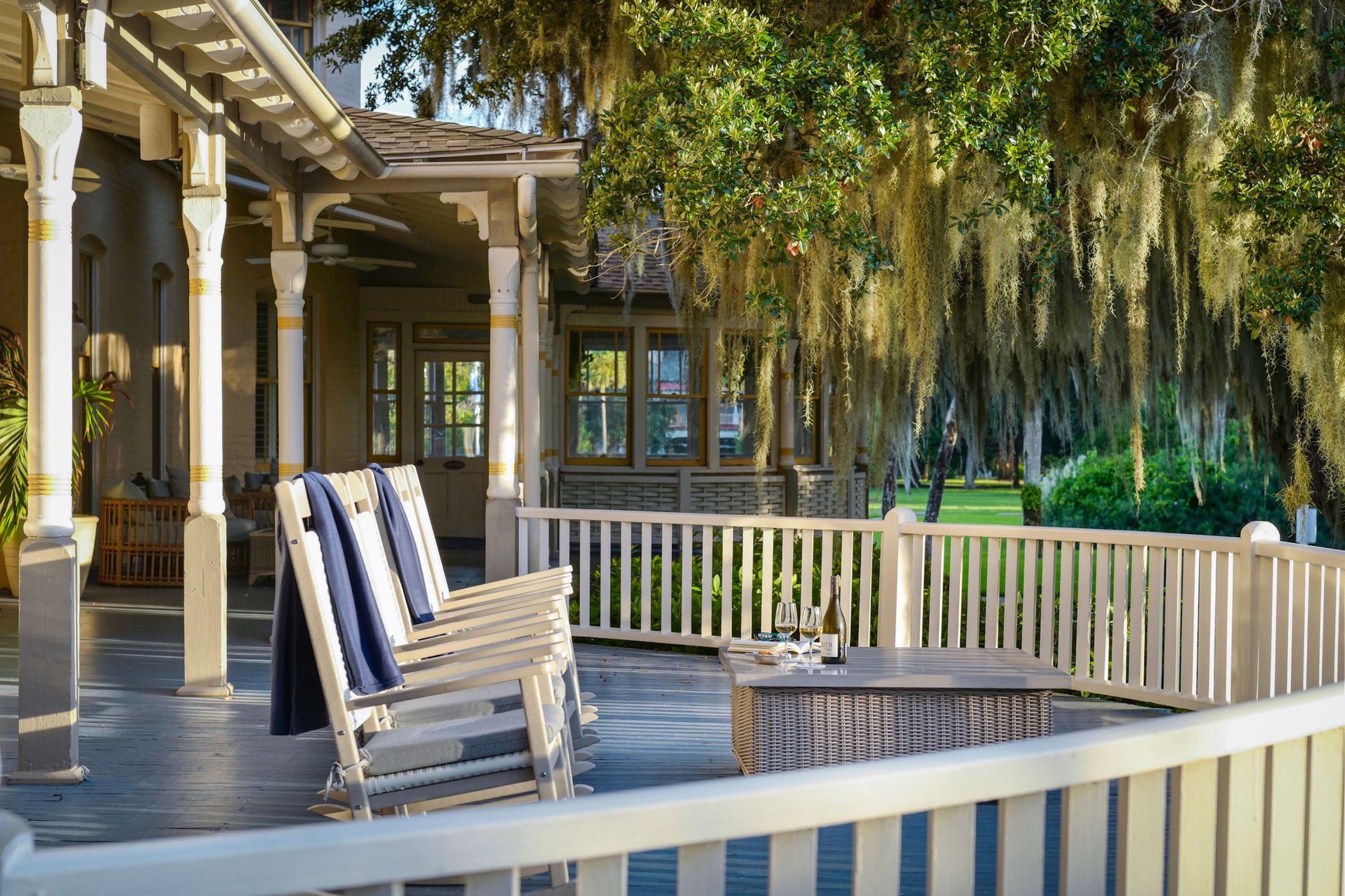 A porch with branches and spanish moss and rocking chairs