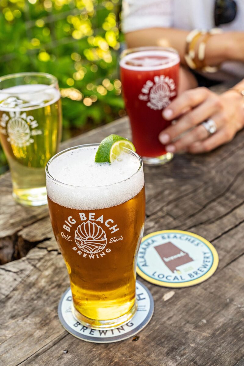 Pint glasses filled with beer on a picnic table at Big Beach Brewing in Gulf Shores Alabama