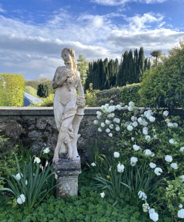A statue of a woman in a garden.