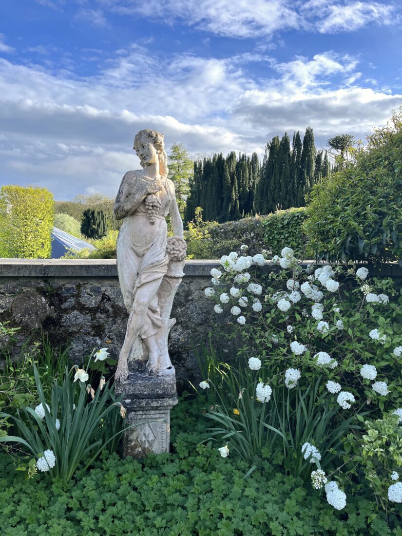 A statue of a woman in a garden.