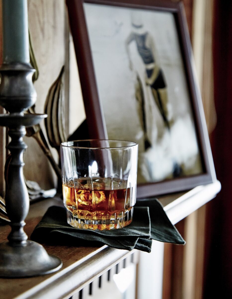 A glass of bourbon on a shelf