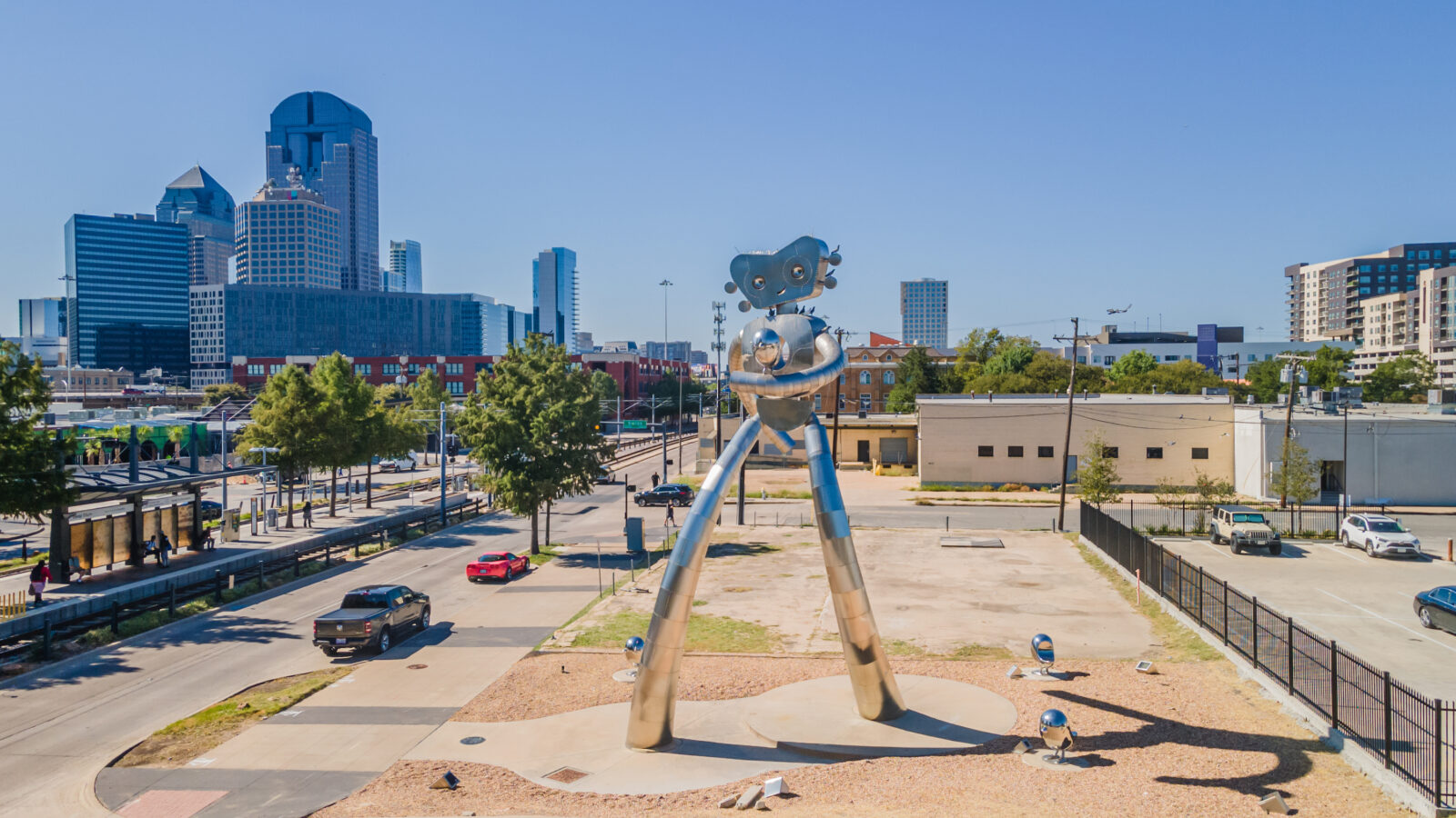 A giant metal sculpture of a walking robot-person in a cityscape.