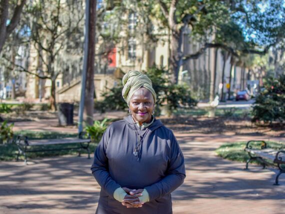 A portrait of a woman standing in a park.