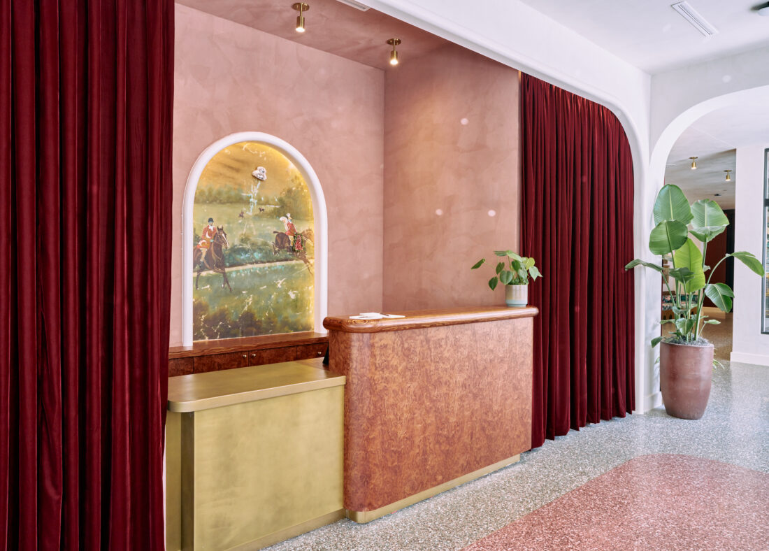 A blush pink and gold lobby desk at Hotel Genevieve.