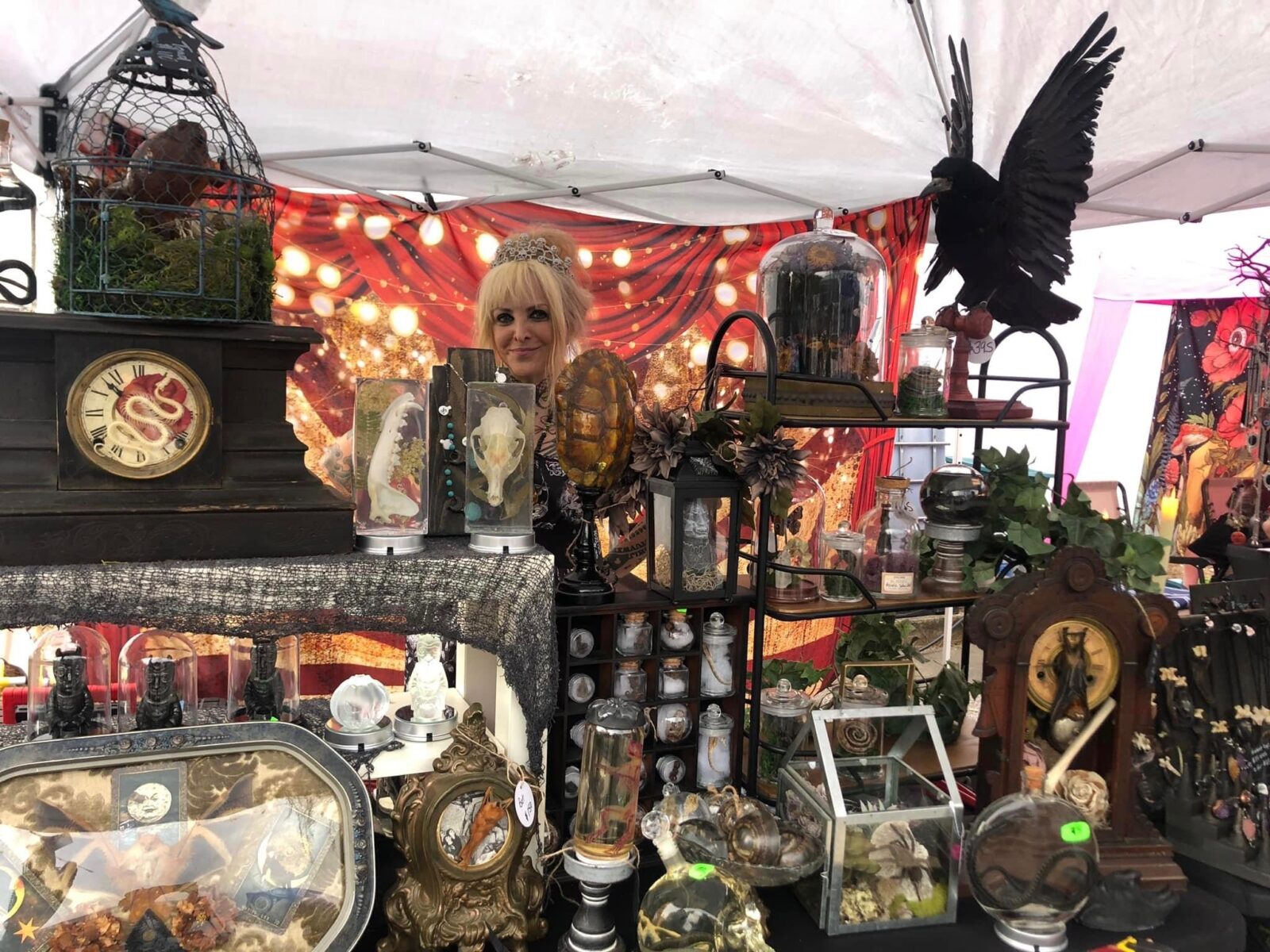 A women in a tent with halloween items for sale.