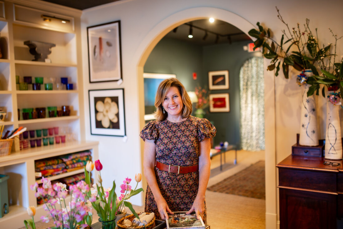 A woman in a patterned dress stands in a home goods store.
