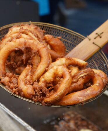 Fried onion rings in a kitchen spider.