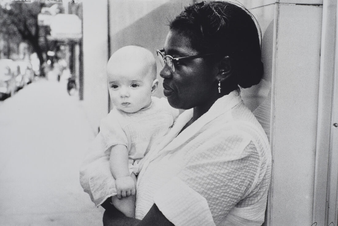 A vintage black and white photo of a woman holding a baby