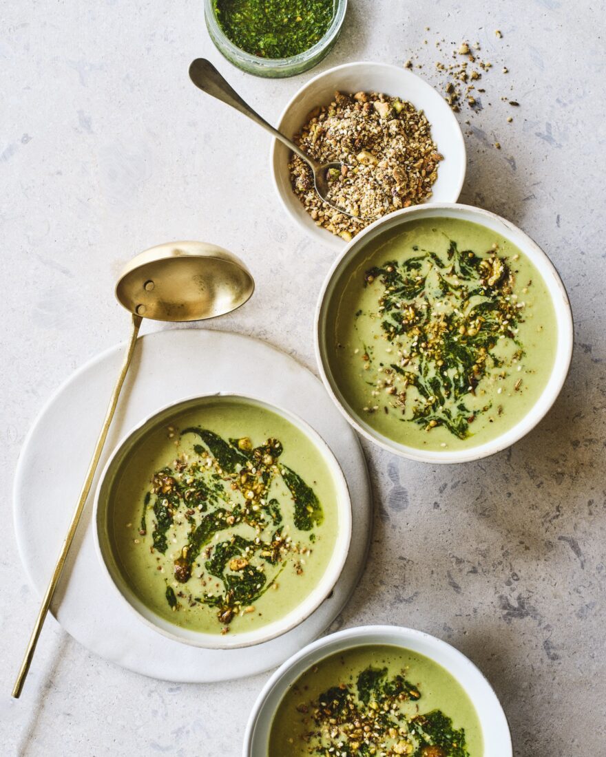 Bowls of green ramp and potato soup on a marble background