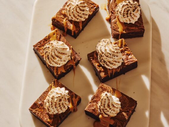 A plate of six brownies topped with toasted marshmallow fluff