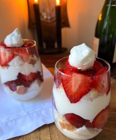 Two glass cups filled with a strawberries and cream dessert