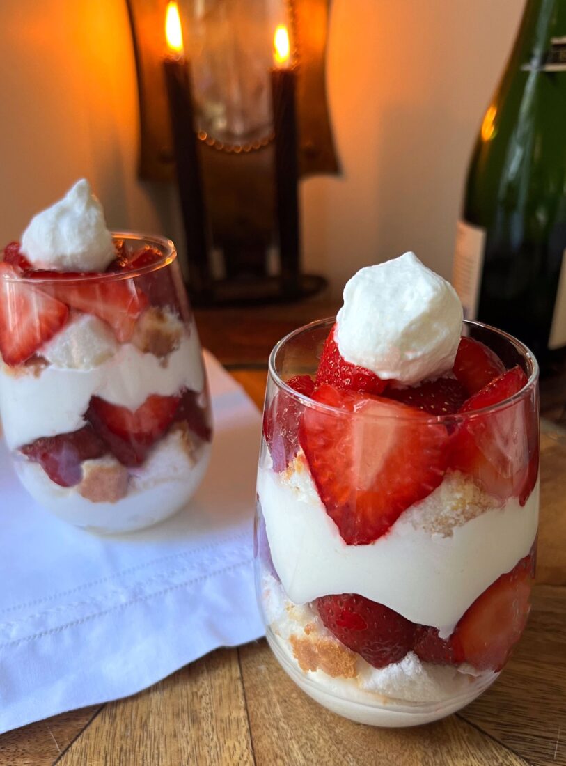 Two glass cups filled with a strawberries and cream dessert