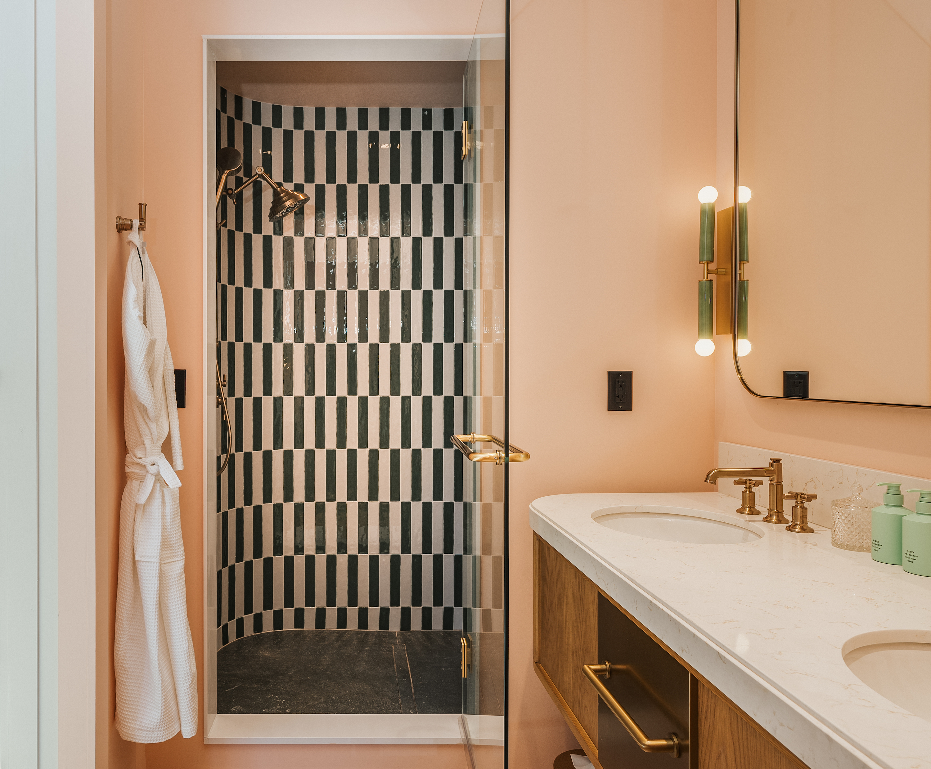 A soft pink bathroom with checkered shower tile.