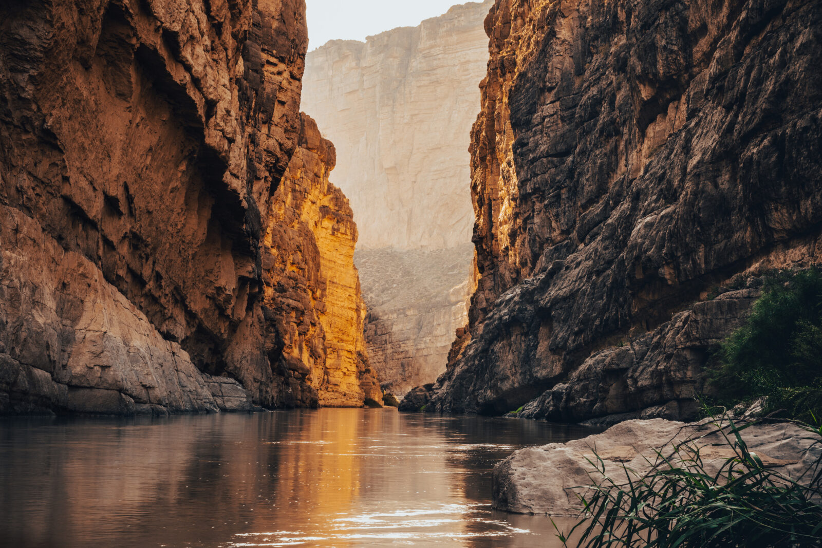 A river snakes through a sunlit canyon