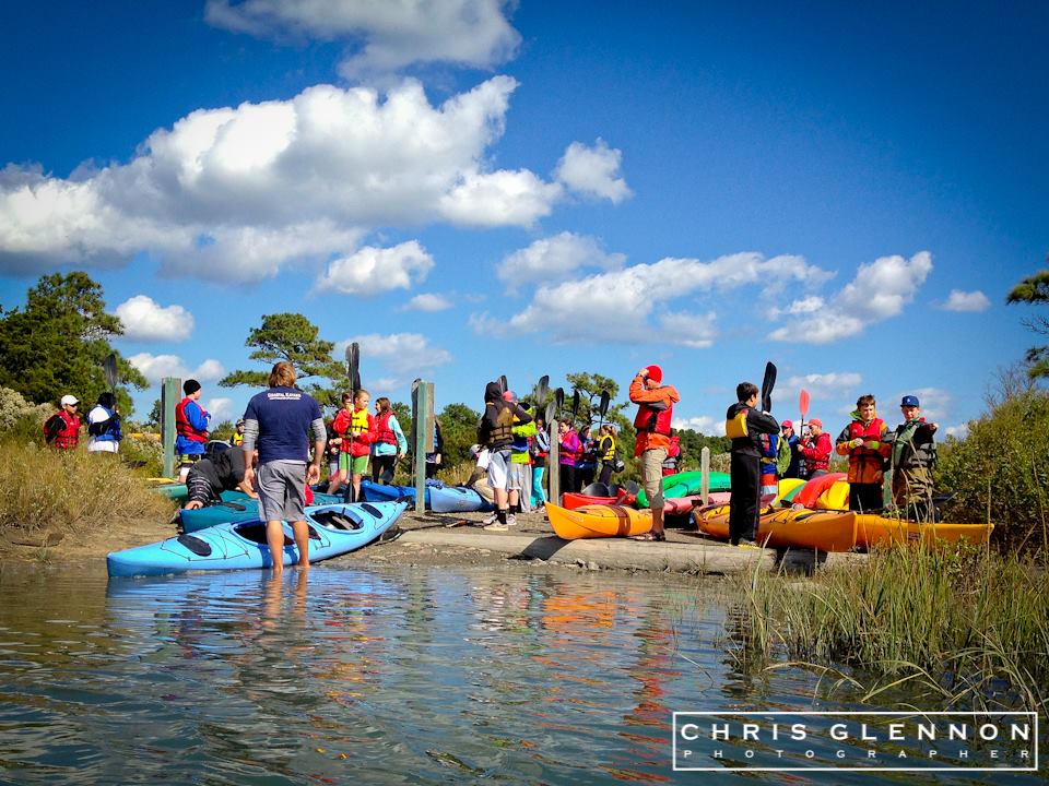 A group of children with kayaks in a marsh