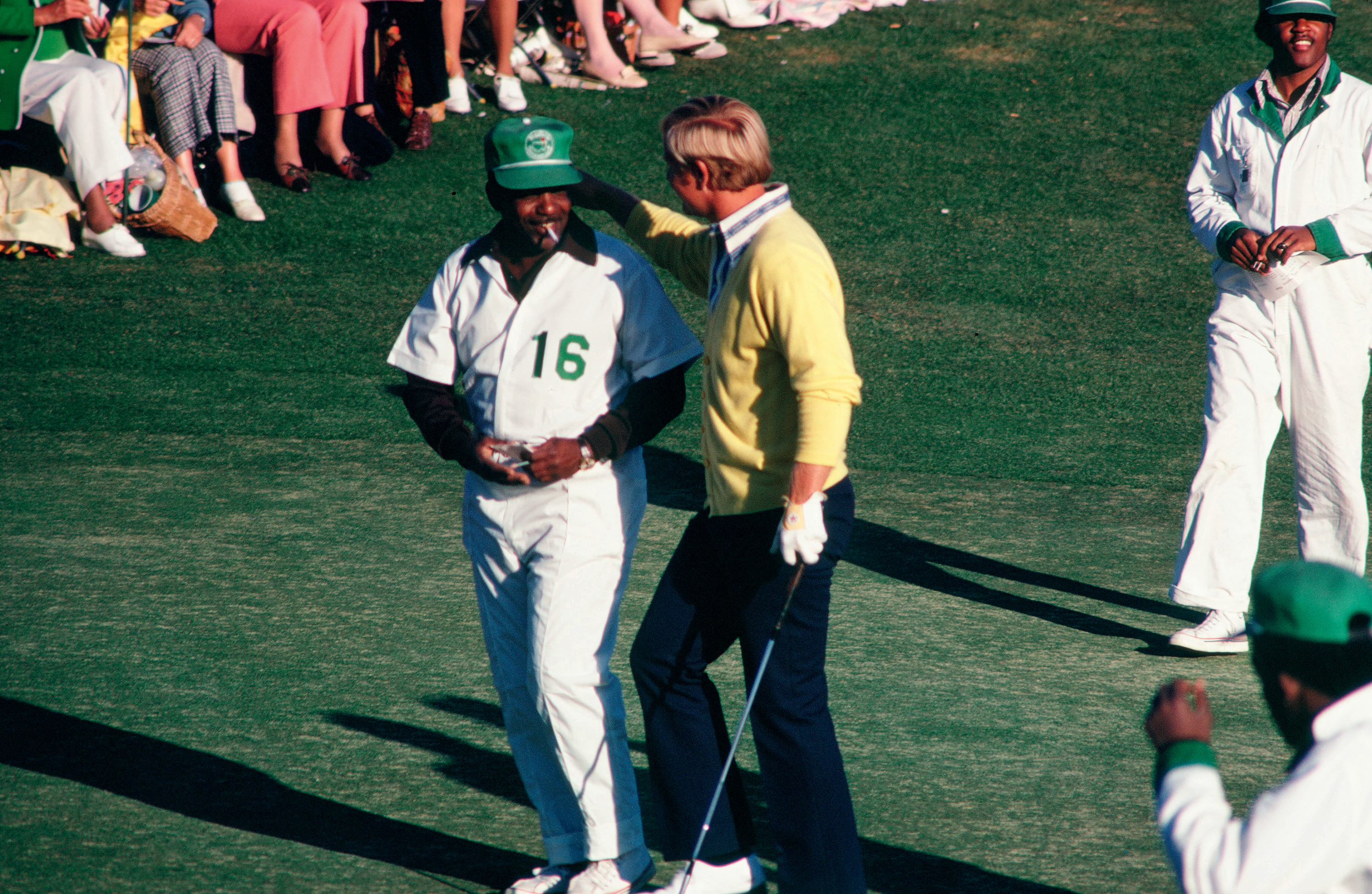 A golfer and caddy walk the greens.