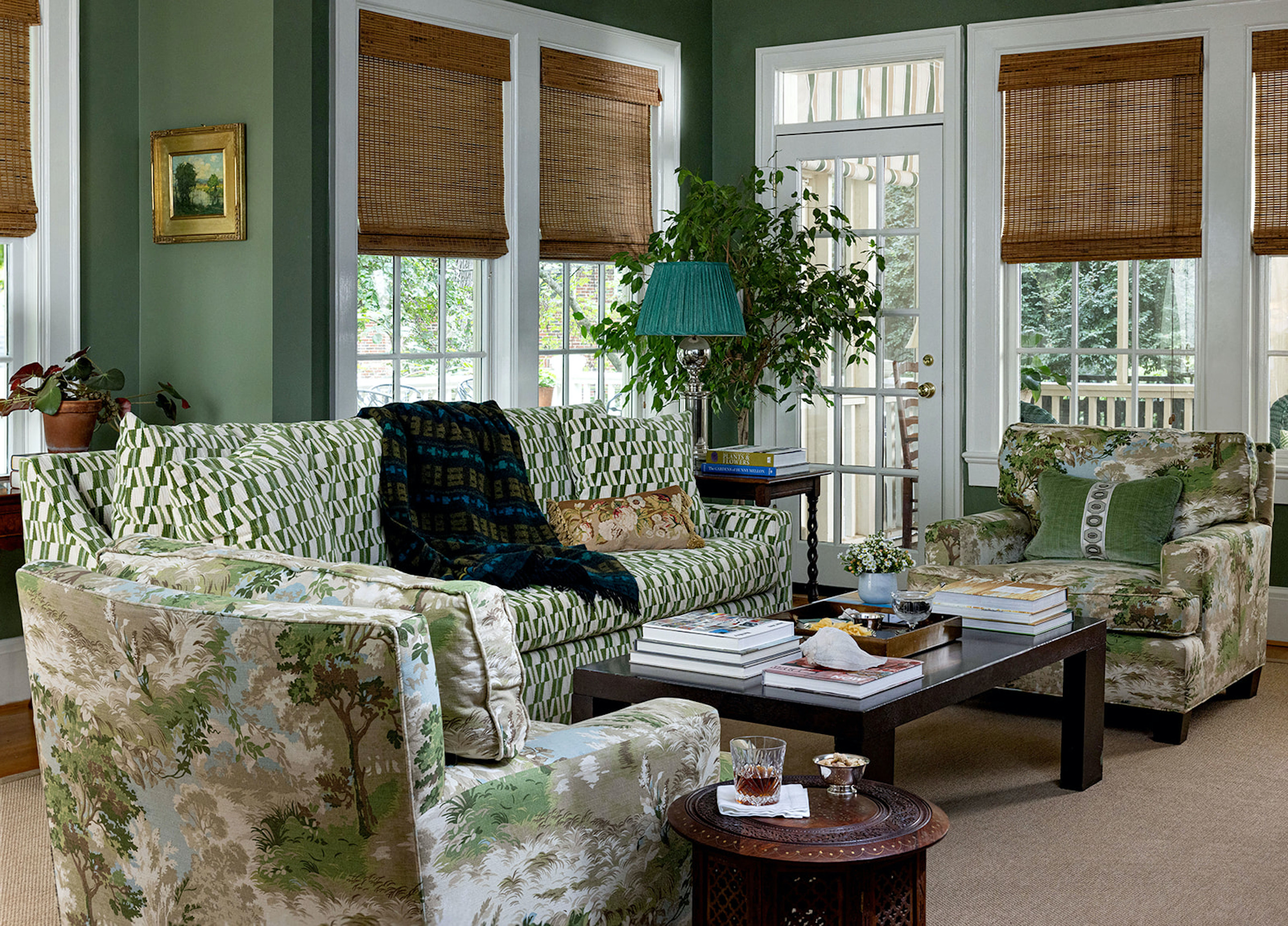 The living room has earthy green walls and chair fabrics with green details.