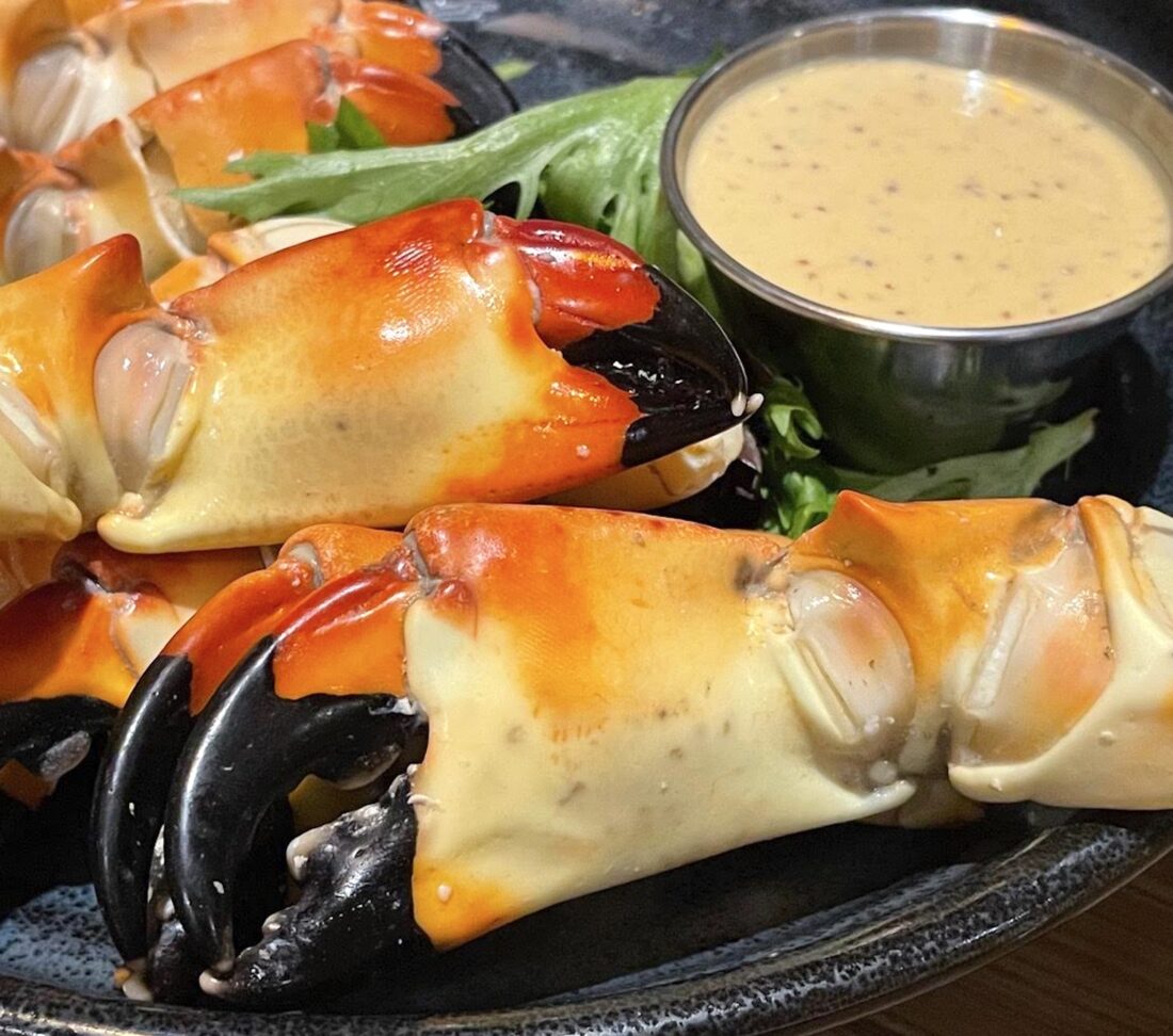 A plate of stone crab claws with mustard dipping suace