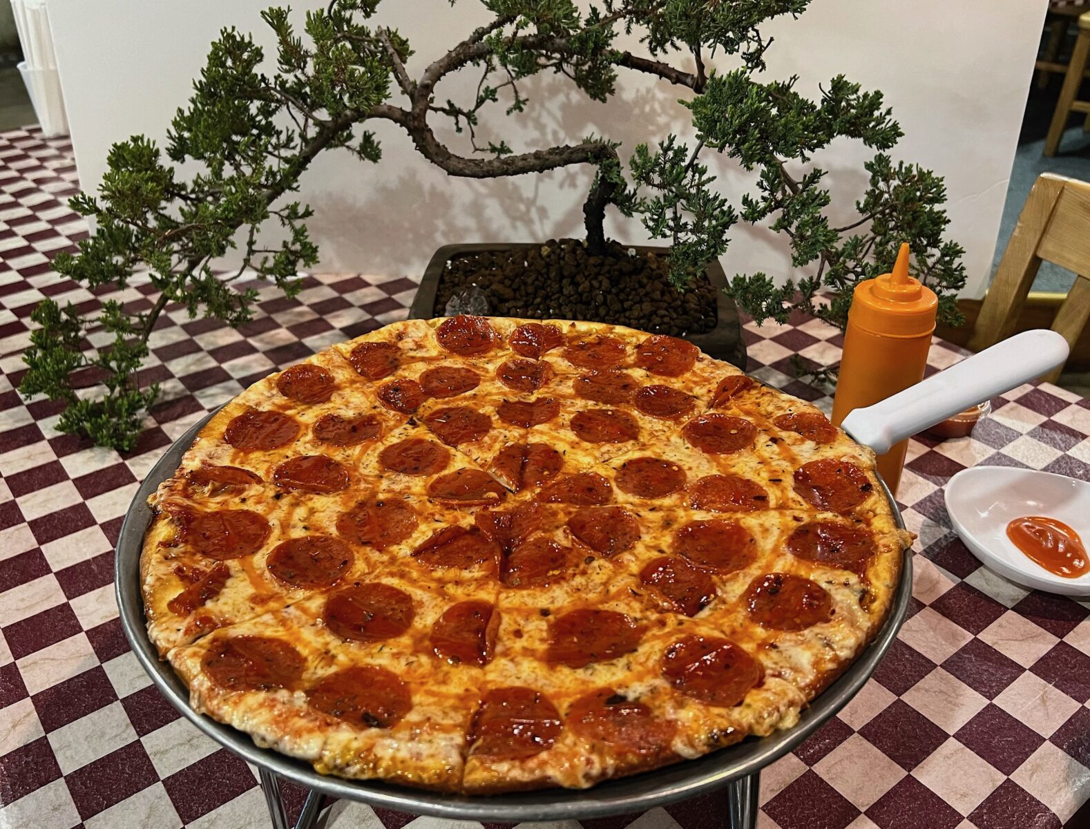 A pan of pizza on a checkered table