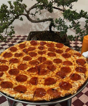 A pan of pizza on a checkered table
