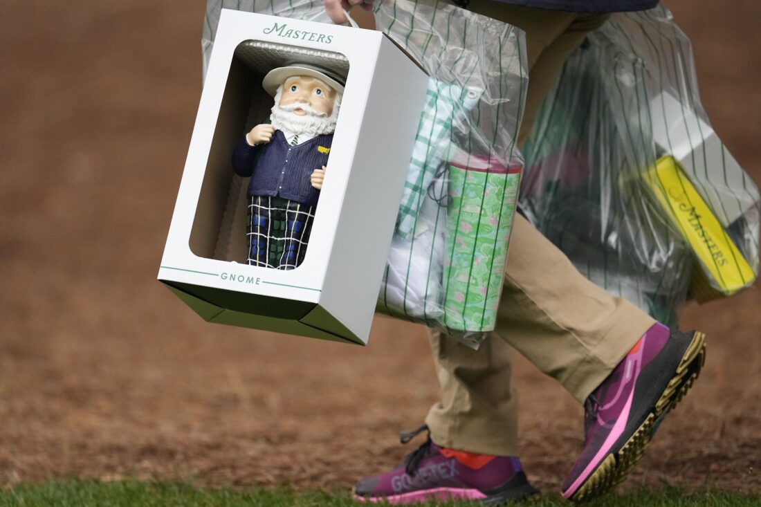 A patrons carries merchandise during a practice round in preparation for the Masters golf tournament at Augusta National Golf Club Tuesday, April 9, 2024, in Augusta, Ga.