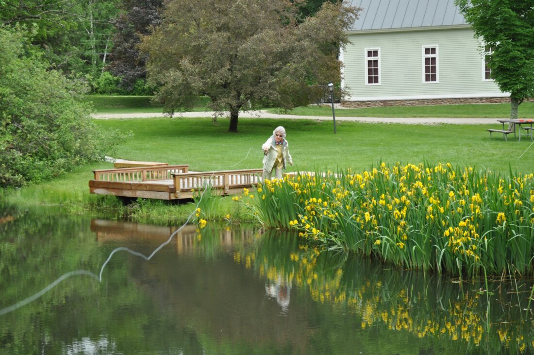 A woman casts a fly rod in a pond